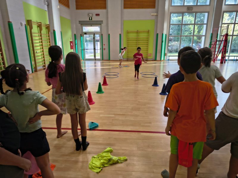 Bambino che prova una capriola assistita durante il corso di motricita