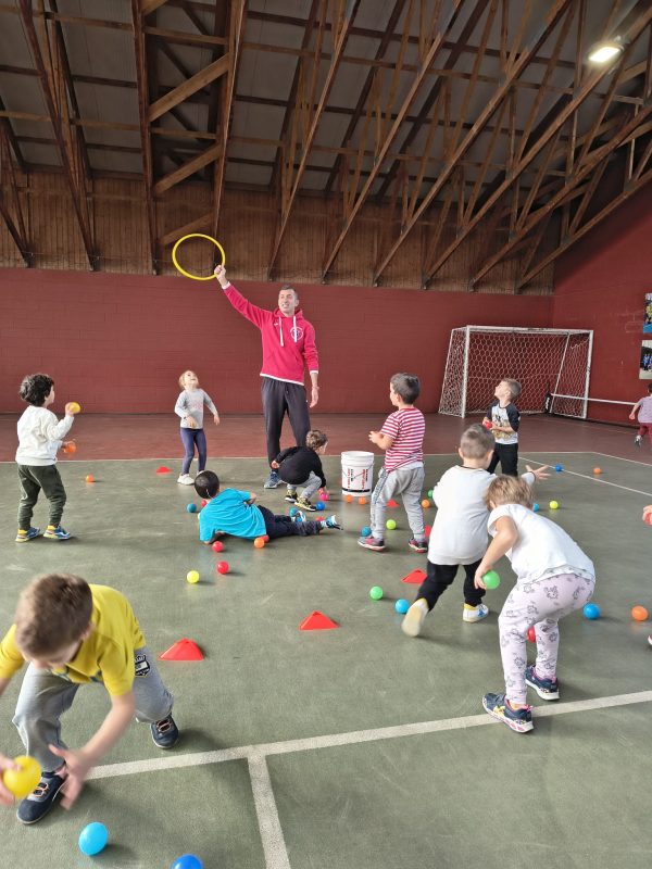 Gruppo di bambini in palestra durante un gioco motorio